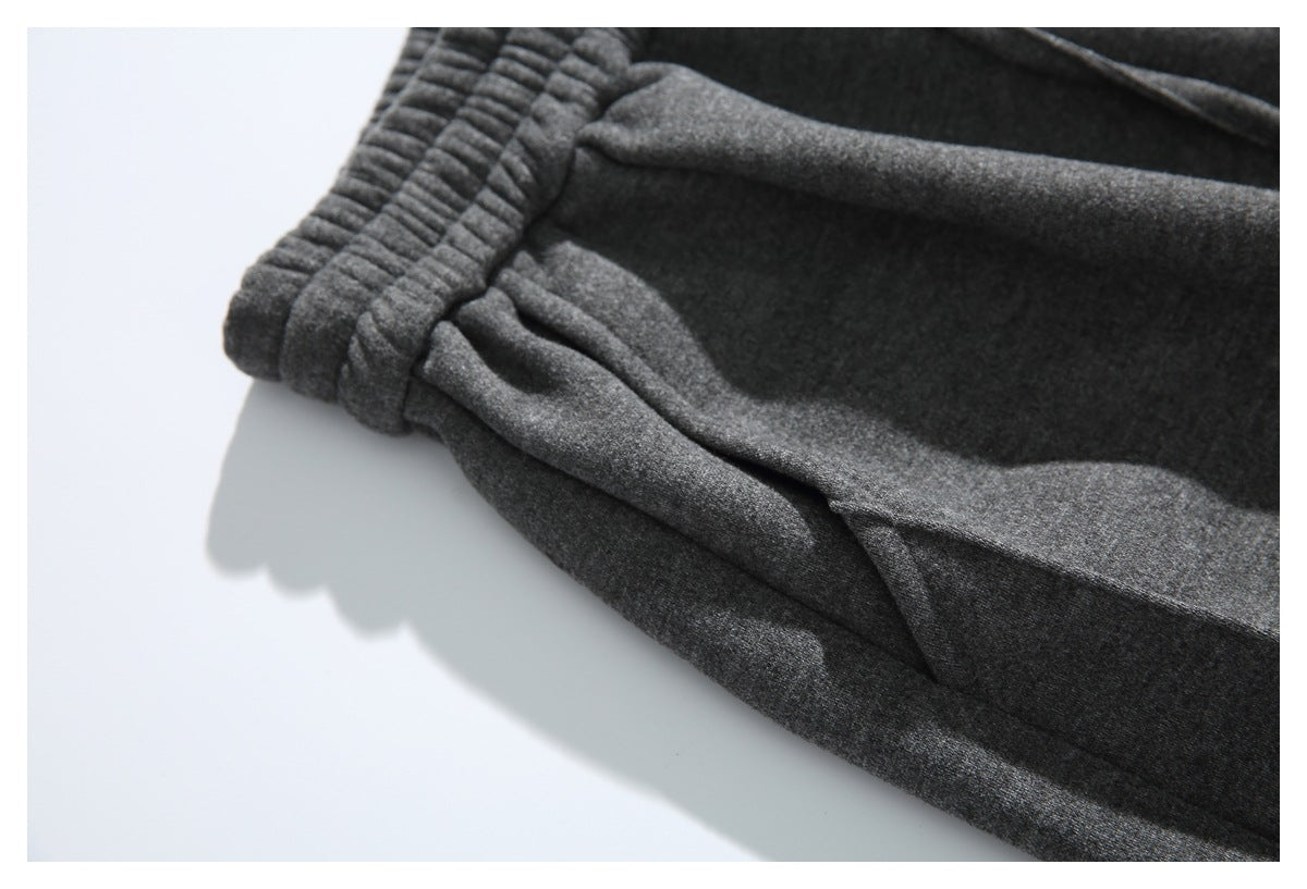 Close-up of dark gray pants showing the elastic waistband and a front pocket opening.