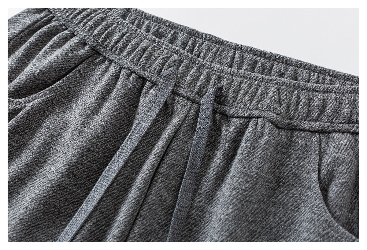 Close-up of heather gray joggers showing the elastic waistband and matching drawstring.