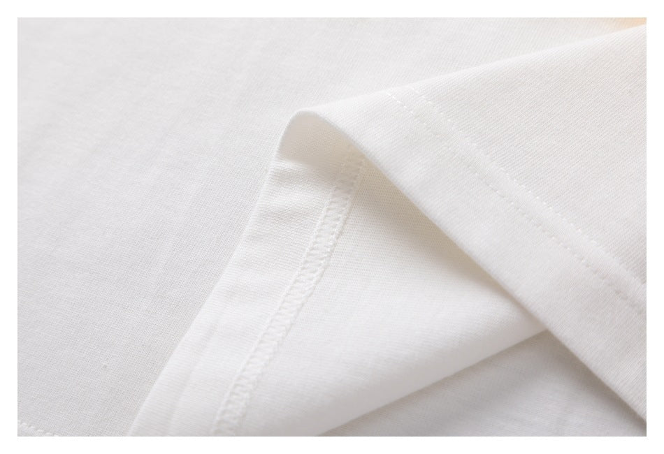 Close-up of white shirt fabric folded to show a stitched seam.