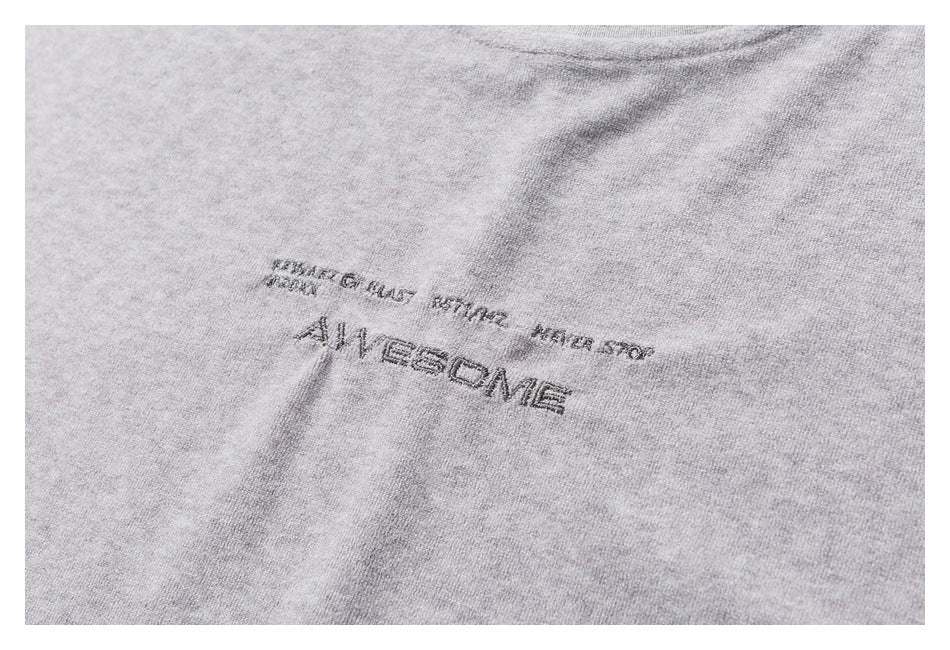 Close-up of dark English lettering, including “AWESOME,” printed on heather-gray fabric.