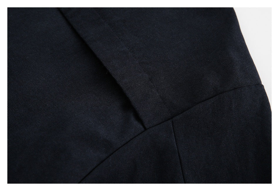 Close-up of dark navy fabric panels with diagonal and curved seams.