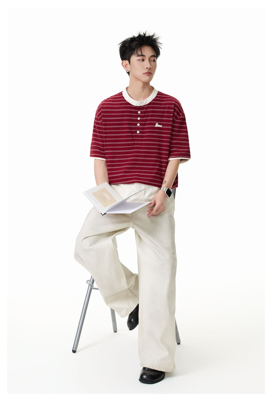 Model wearing a burgundy short-sleeve striped henley tee with a white collar and small chest embroidery.