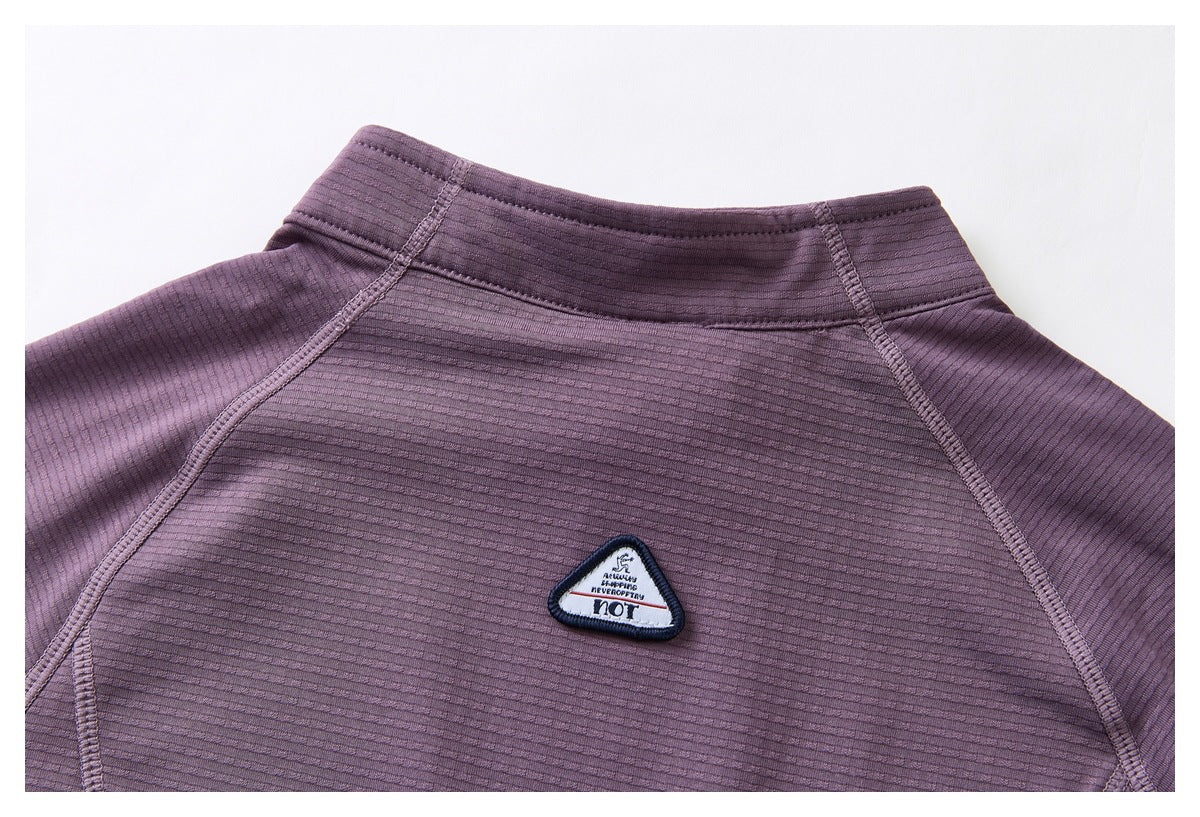 Close-up of the purple jacket's back collar and ribbed upper back with a small triangular embroidered patch.