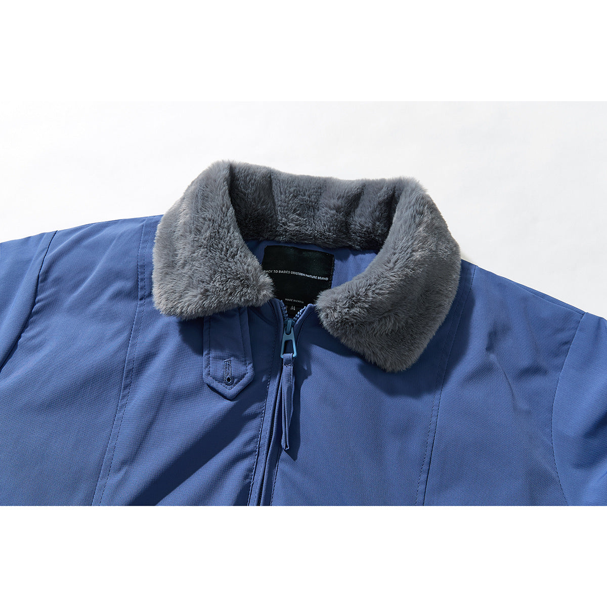 Close-up of a blue jacket's gray plush collar, front zipper, and upper front.