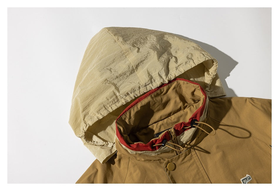 Tan jacket hood and collar with cream lining, red trim, and adjustable drawcords.