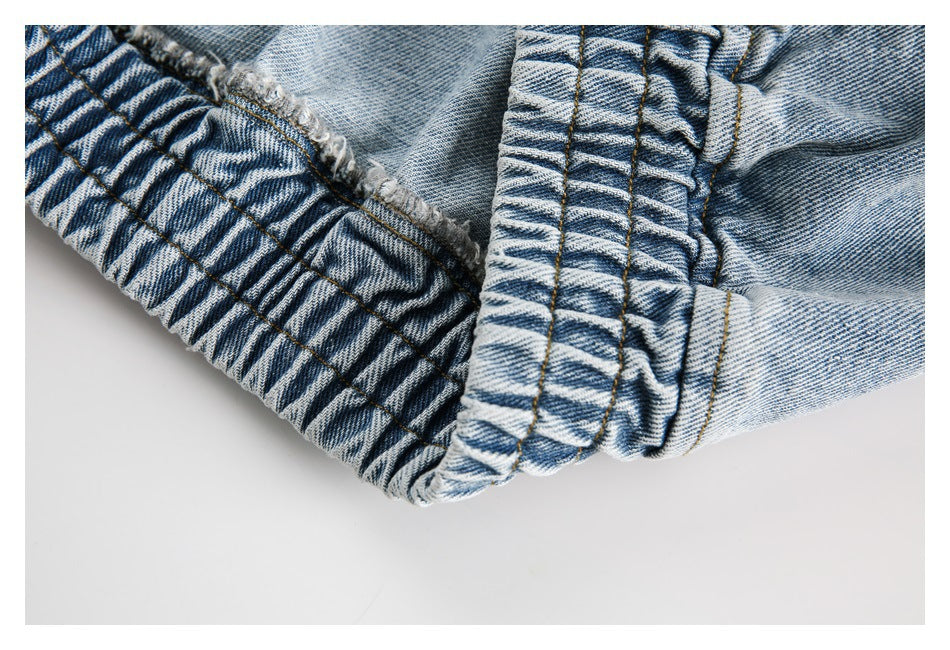 Close-up of a gathered, elasticized denim edge with visible stitching.