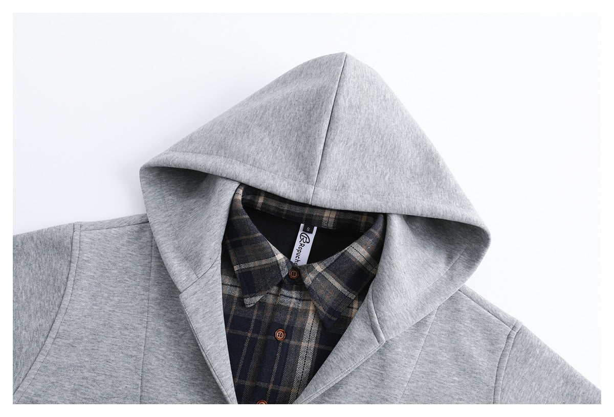 Close-up of a light gray hood framing a dark plaid collared shirt with brown buttons and a visible neck label.