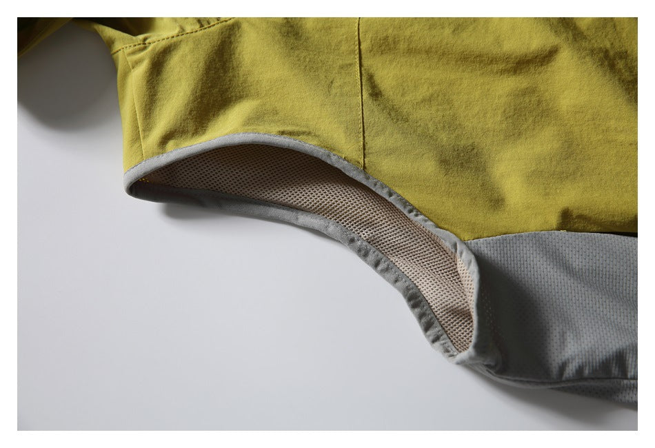 Close-up of gray mesh underarm panel and trim on the mustard vest.