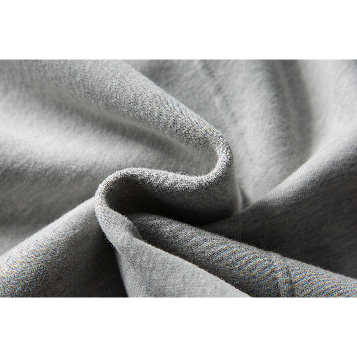 Macro view of light gray fabric folded to show its textured surface.