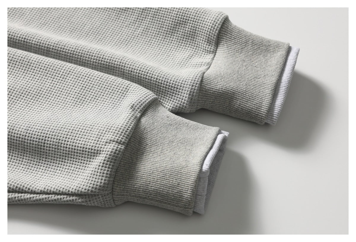 Close-up of light gray waffle-textured sleeves with wide ribbed cuffs.