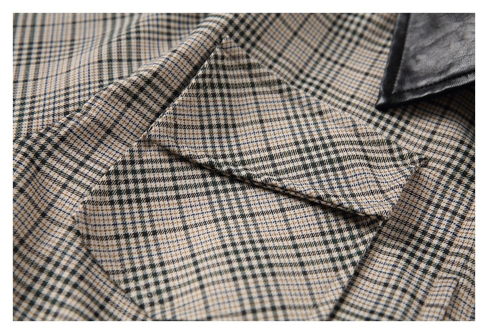 Close-up of a flap chest pocket on the beige and dark plaid shirt, with part of the black collar visible.