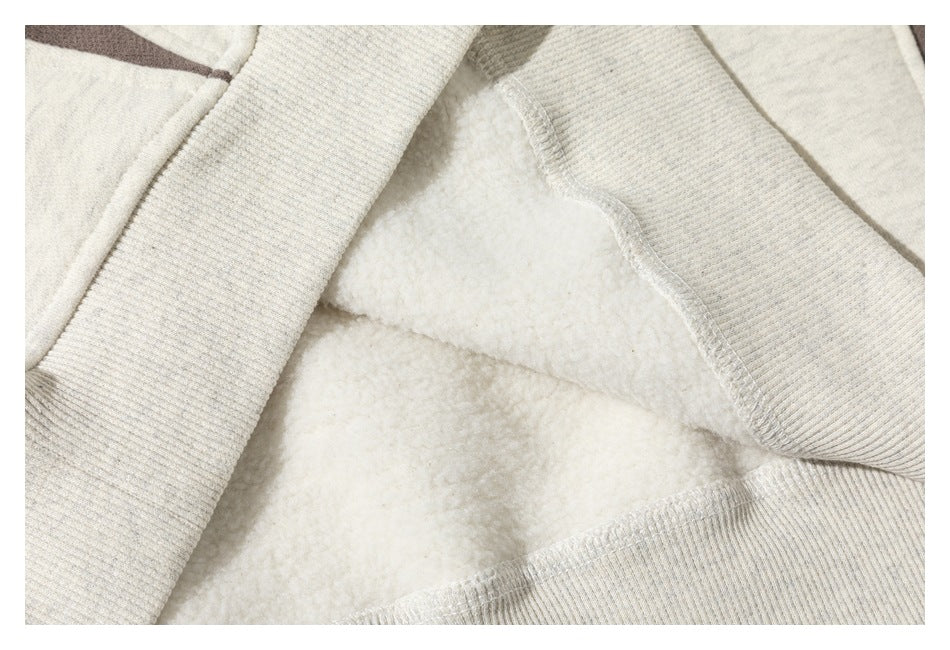Inside view of an off-white sweatshirt showing soft-looking fleece, seams, and ribbed trim.