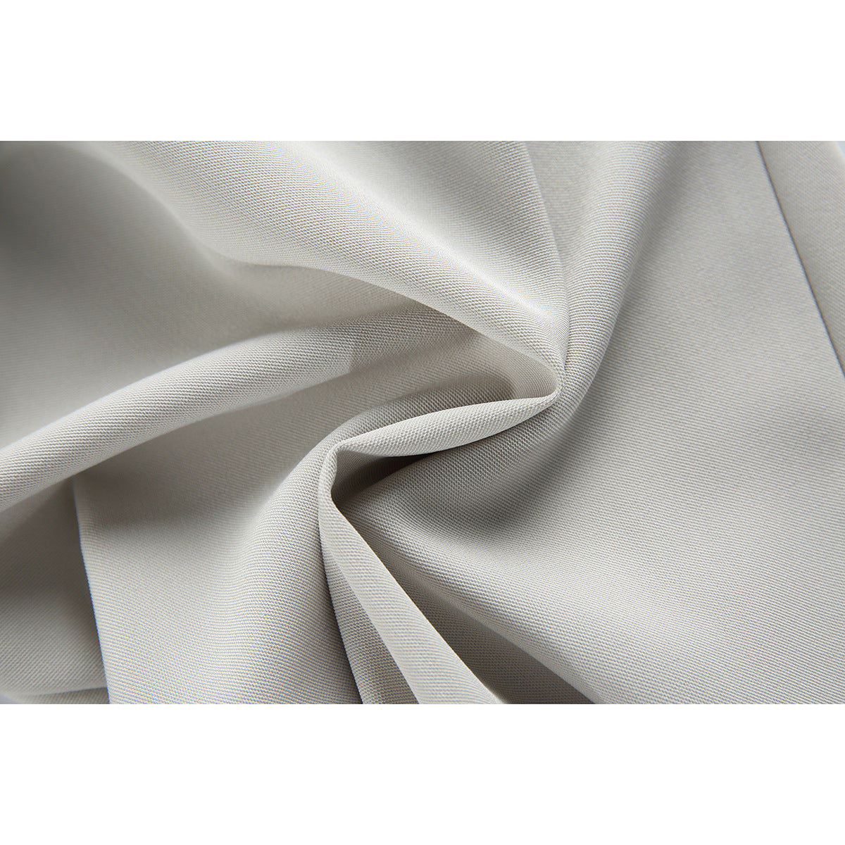 Close-up of light gray trouser fabric draped to show its fine woven texture.