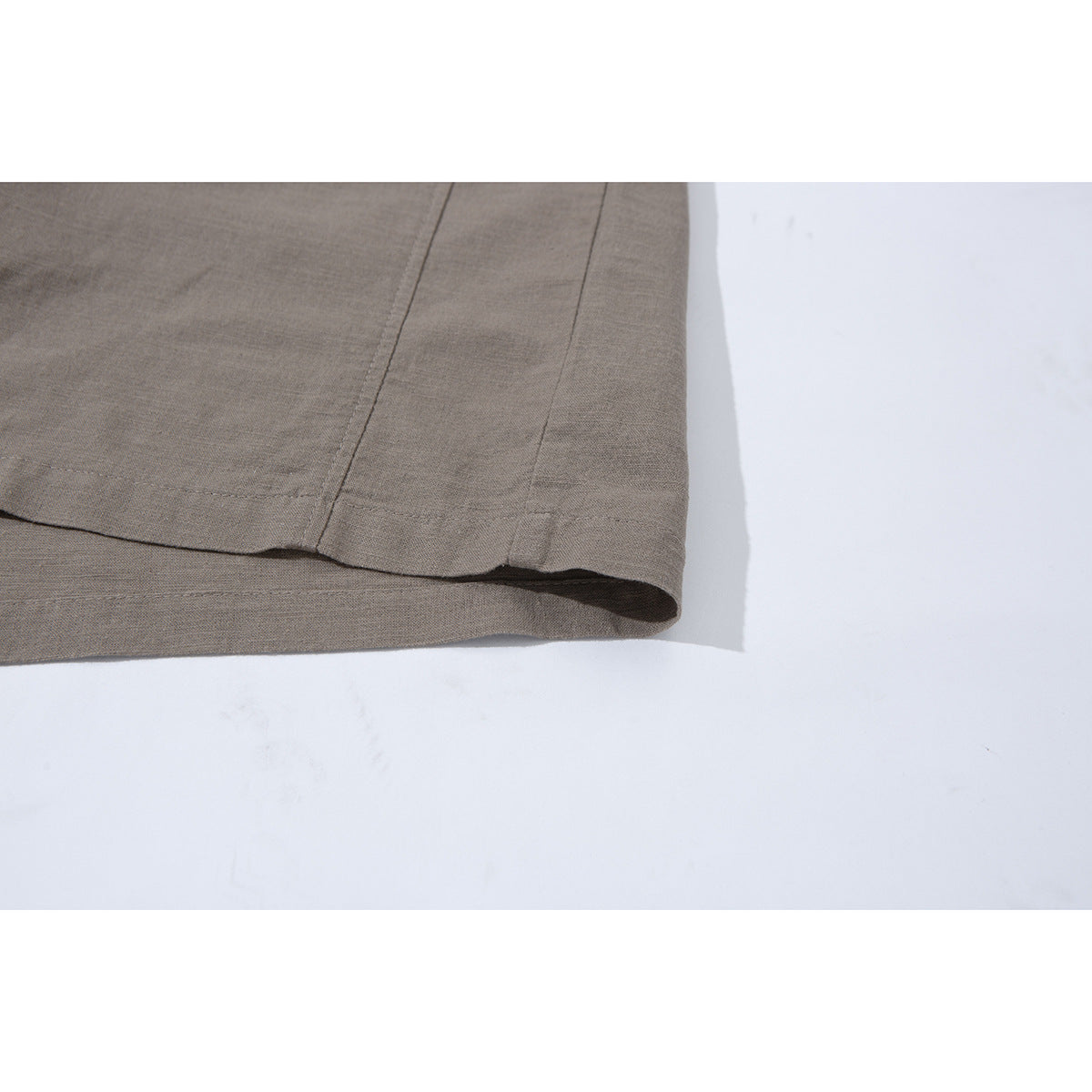 Close-up of the taupe shirt's straight hem and stitching.