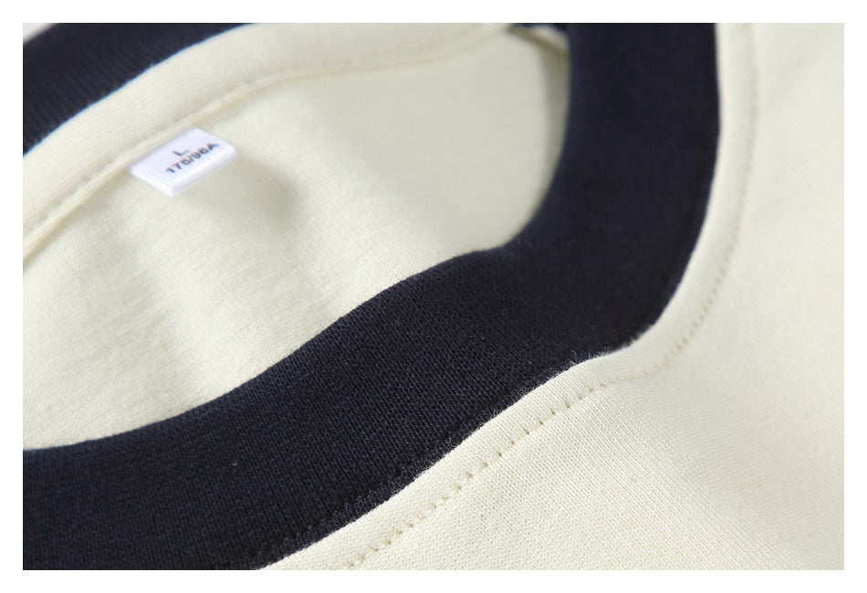 Extreme close-up of the black ribbed collar and cream fabric, with a small inner size label.