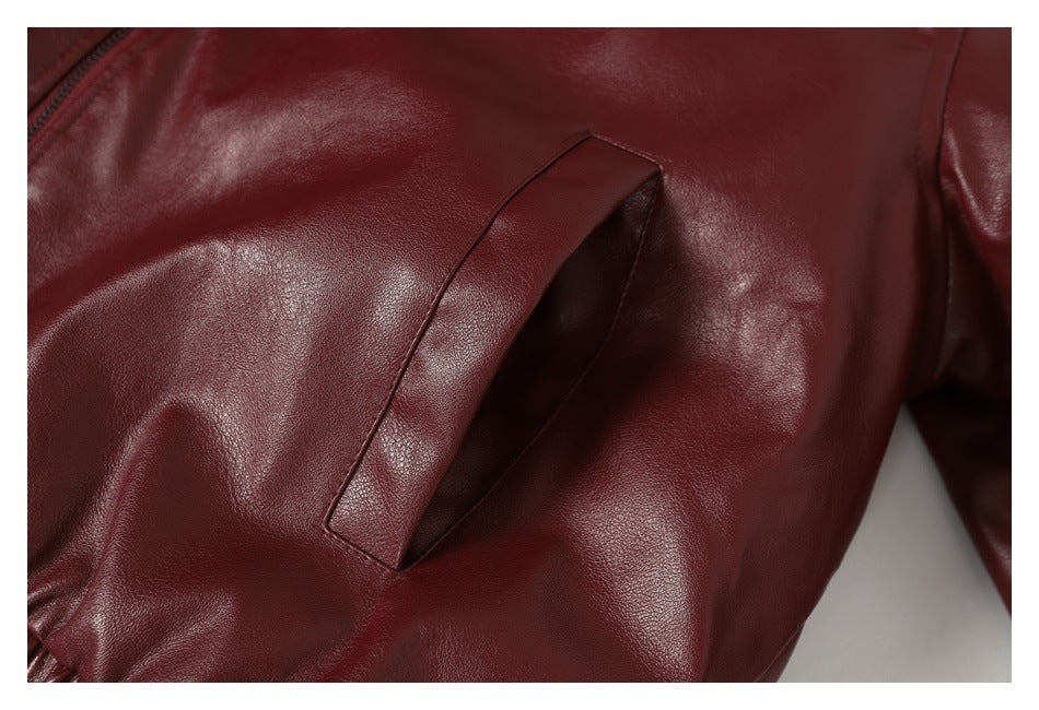 Close-up of a slanted welt pocket on a burgundy jacket.