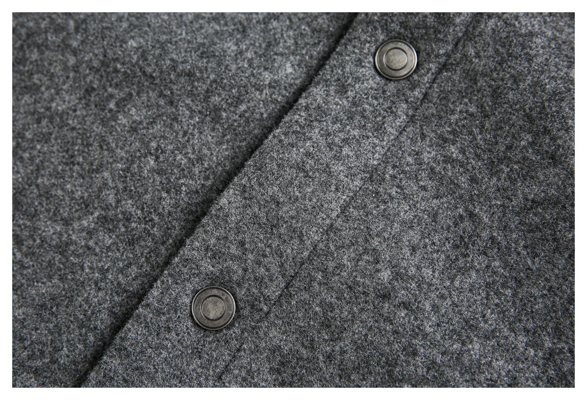 Close-up of gray jacket fabric and two round metal snap buttons.