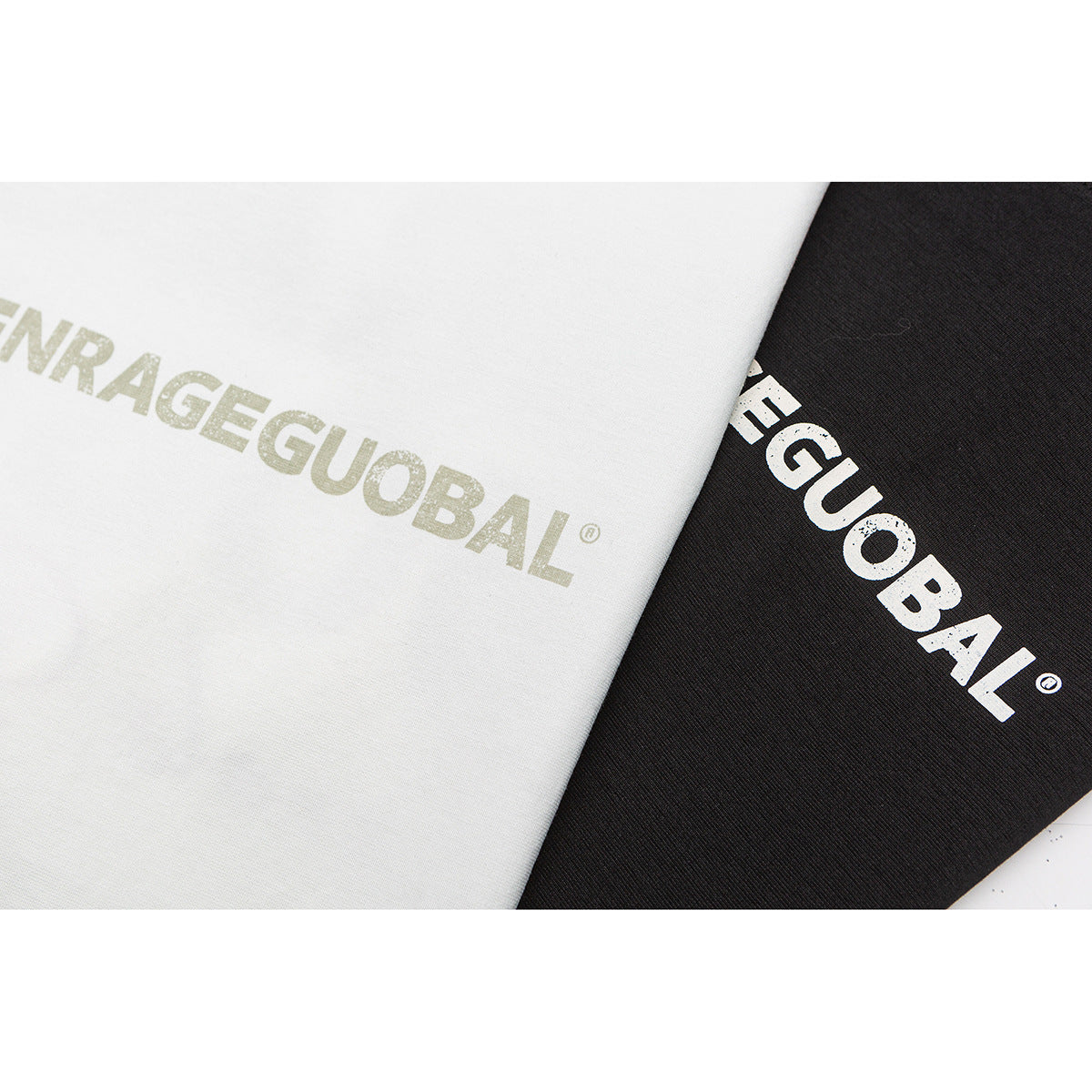 Close-up of white and black T-shirt fabric with large printed lettering.