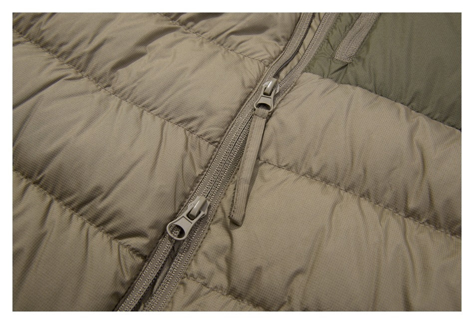 Close-up of the jacket's front zipper, showing two sliders and the surrounding taupe quilting.