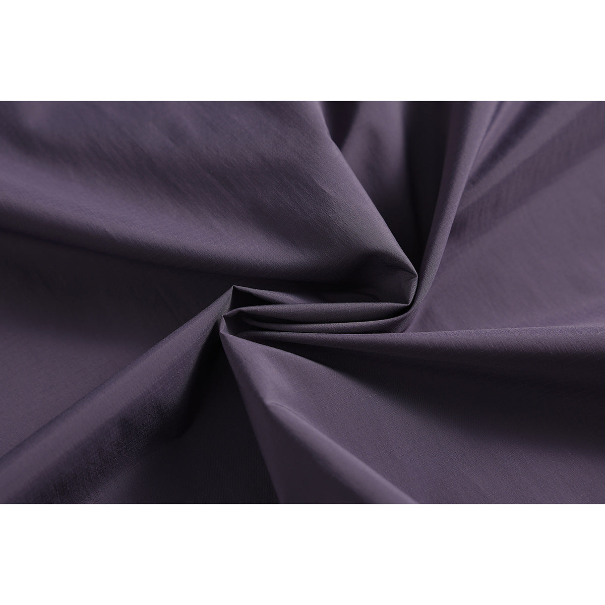 Macro view of dark purple jacket fabric arranged in soft folds.