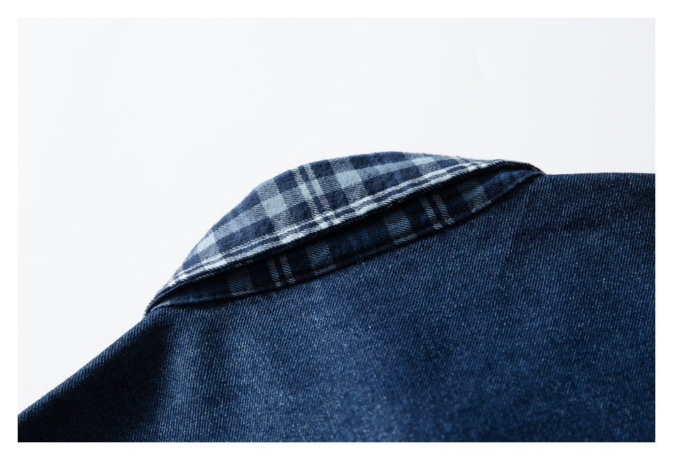 Close-up of a dark indigo denim shirt collar showing a blue and gray plaid underside.