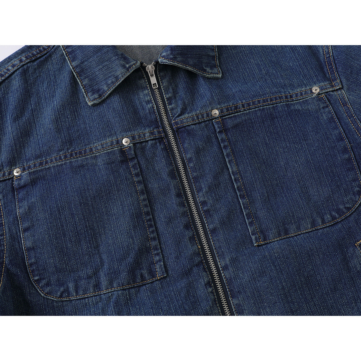 Close-up of the dark blue denim jacket front, showing its zipper and two large buttoned chest pockets.