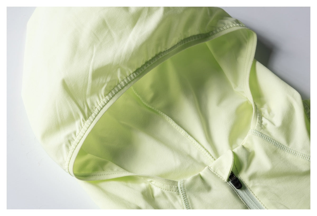 Close-up of the pale lime jacket's hood lining, stitched seams, and short front zipper.