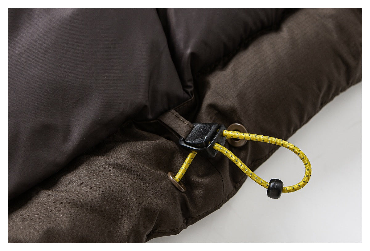 Close-up of a dark brown padded jacket’s yellow cord loop and black toggle adjustment.