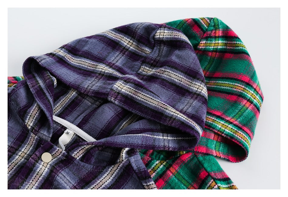 Close-up of purple and green-red plaid shirt hoods displayed together, showing the fabric pattern and snap closure.