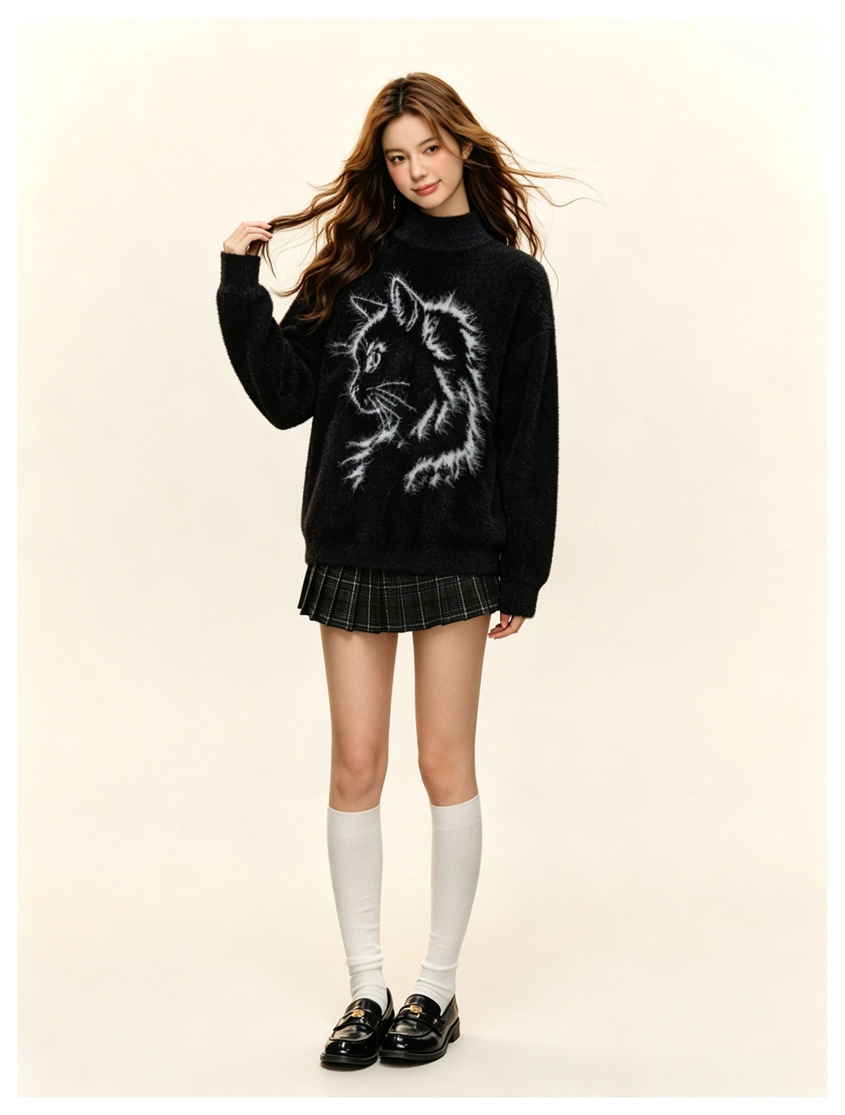 Model wearing a black fuzzy high-neck sweater with a white cat graphic, plaid mini skirt, white knee socks, and black