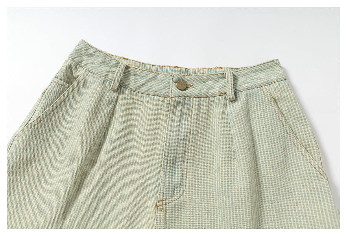Close-up of the front waistband and button on pale blue striped shorts.