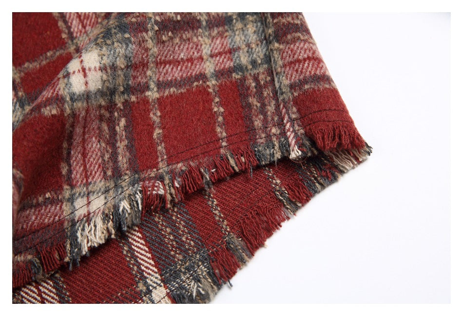 Close-up of the shirt's layered, frayed hem in red, cream, and charcoal plaid.