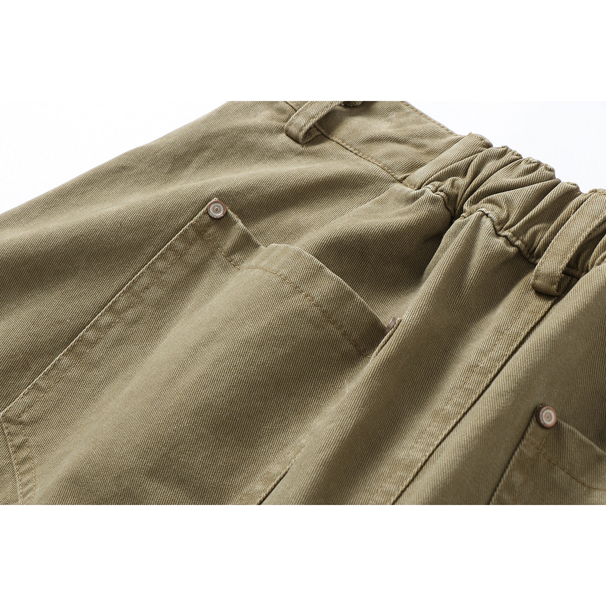 Close-up of tan pants with a gathered waistband, belt loops and buttoned patch pockets.
