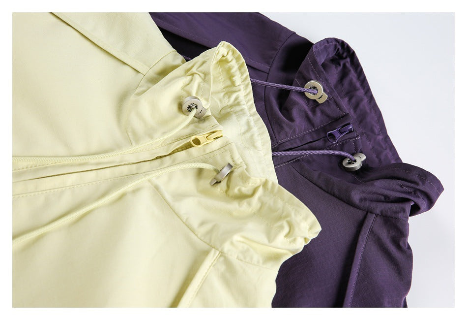 Close-up of pale yellow and deep purple garments with buttoned waist tabs, zippers and drawcords.
