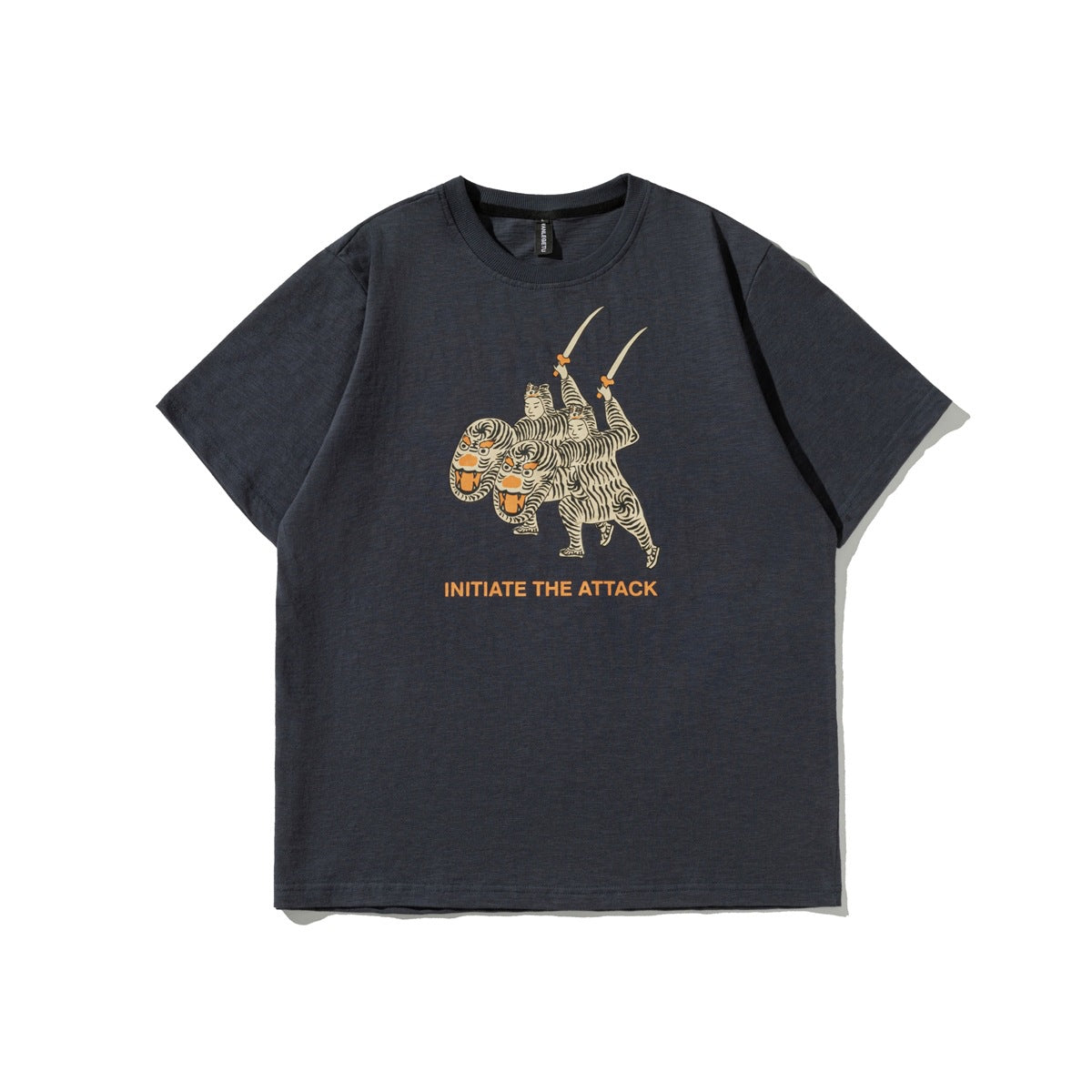 Navy short-sleeve crew-neck T-shirt with tiger-costume sword graphic and orange INITIATE THE ATTACK text, flat lay