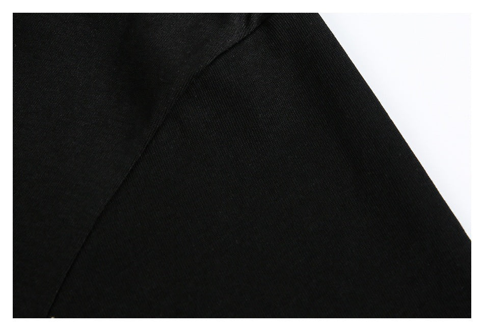 Close-up of black garment fabric and a curved seam against a white background.