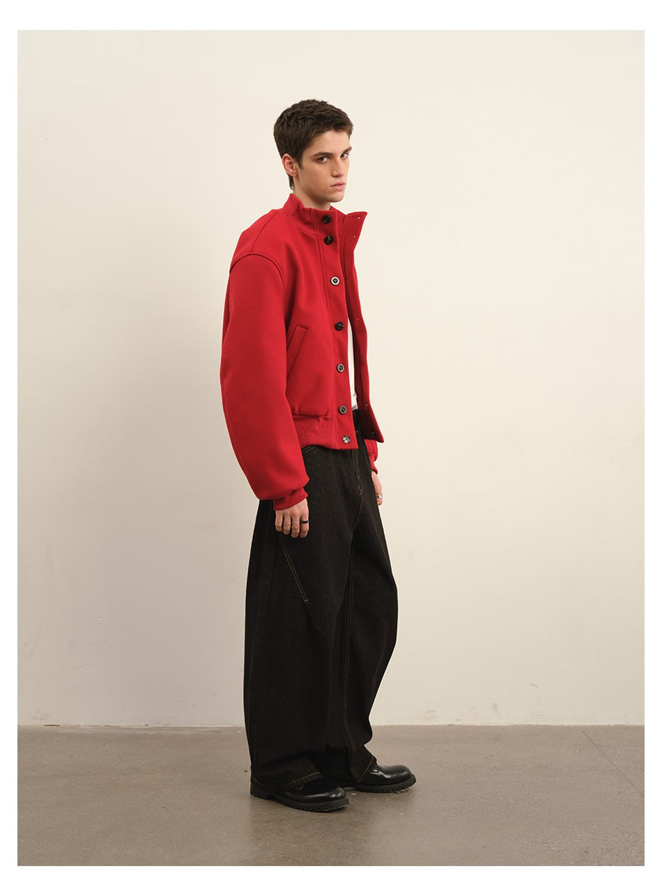 Model wearing a bright red high-collar jacket with a button front and black wide-leg trousers.