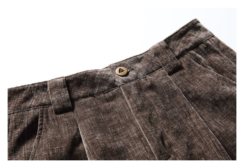 Close-up of the brown trousers’ waistband, belt loop and button closure.