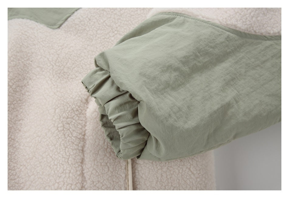 Close-up of a sage-green jacket sleeve cuff beside cream fleece panels.