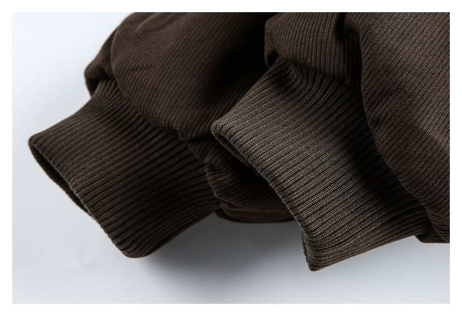 Close-up of two ribbed cuffs on a dark brown garment.