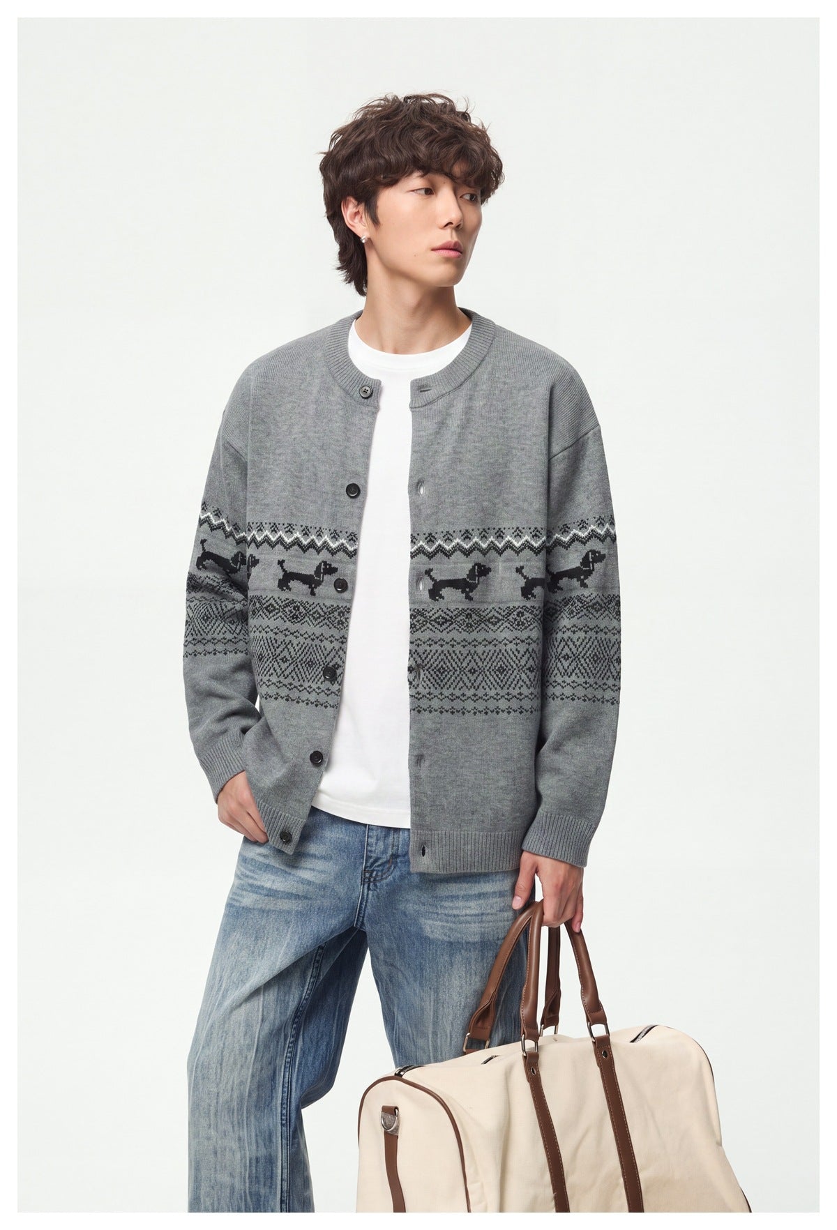 Model wearing gray patterned button-front cardigan over a white tee with blue jeans, holding a canvas bag