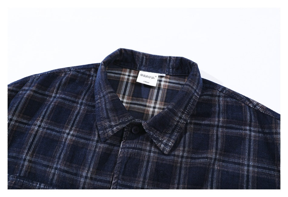 Upper front of a dark navy plaid shirt laid flat, showing its collar, button, and neck label.