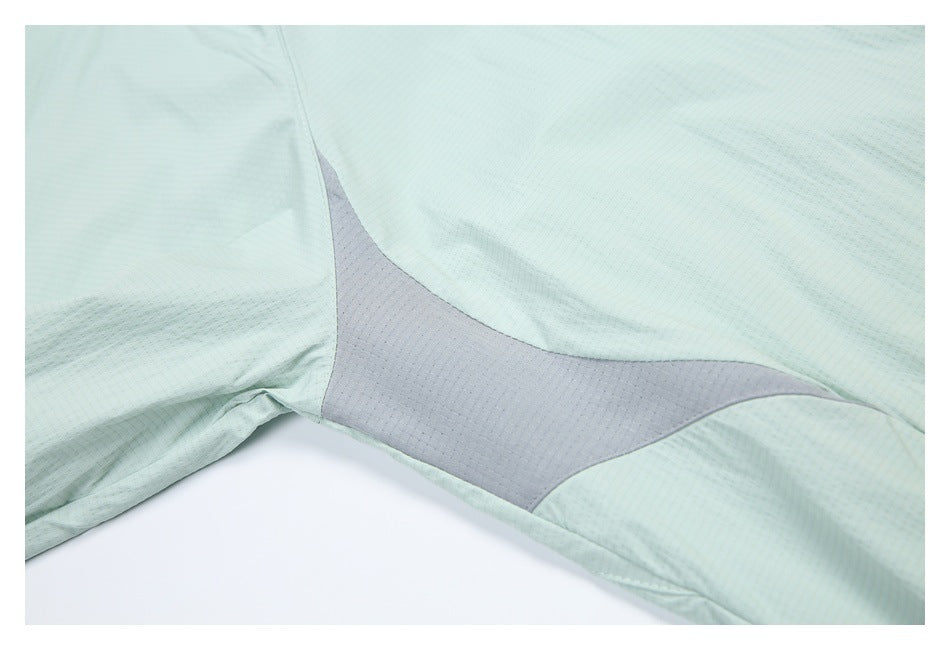 Close-up of a pale mint jacket with a gray underarm ventilation panel.