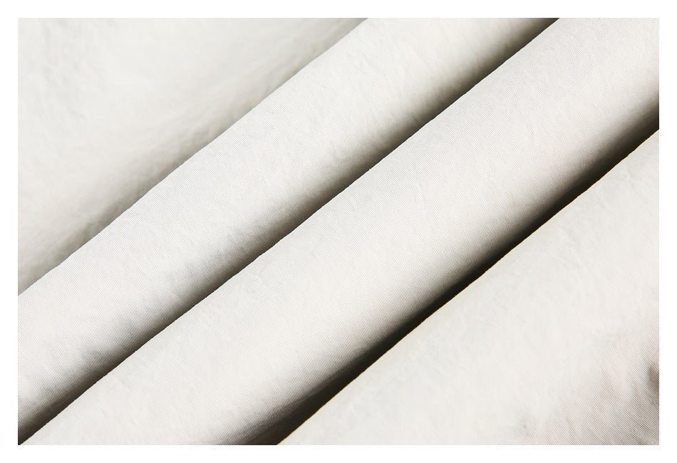 Close-up showing the fine surface texture of light beige garment fabric.