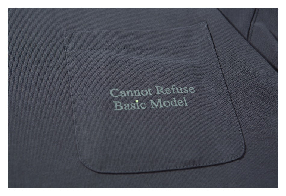 Close-up of a charcoal-gray shirt pocket with the words “Cannot Refuse Basic Model” printed on it.