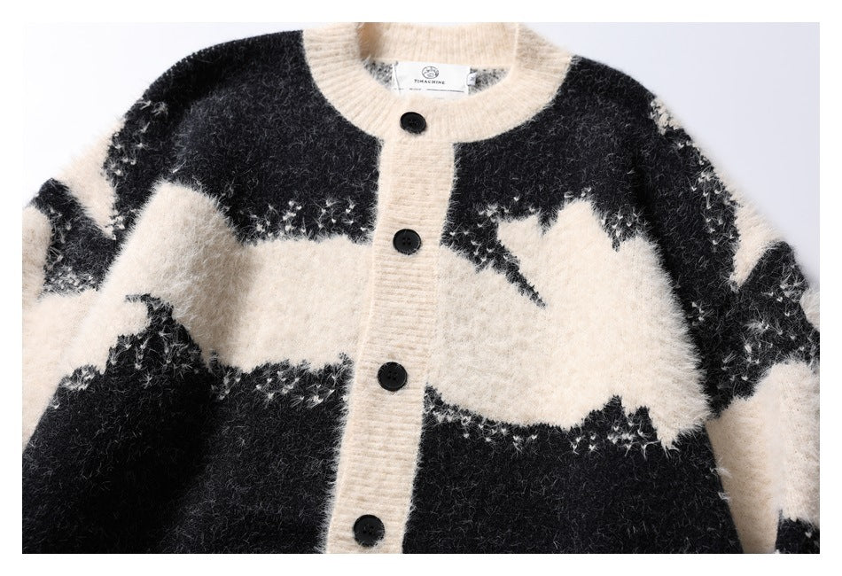 Front view of a black and ivory fuzzy cardigan with an abstract pattern, ivory trim, and black buttons.