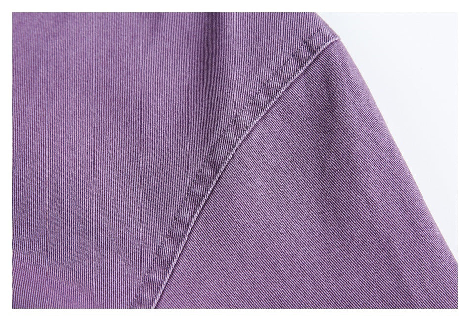 Close-up of purple garment fabric and a curved double-stitched seam.