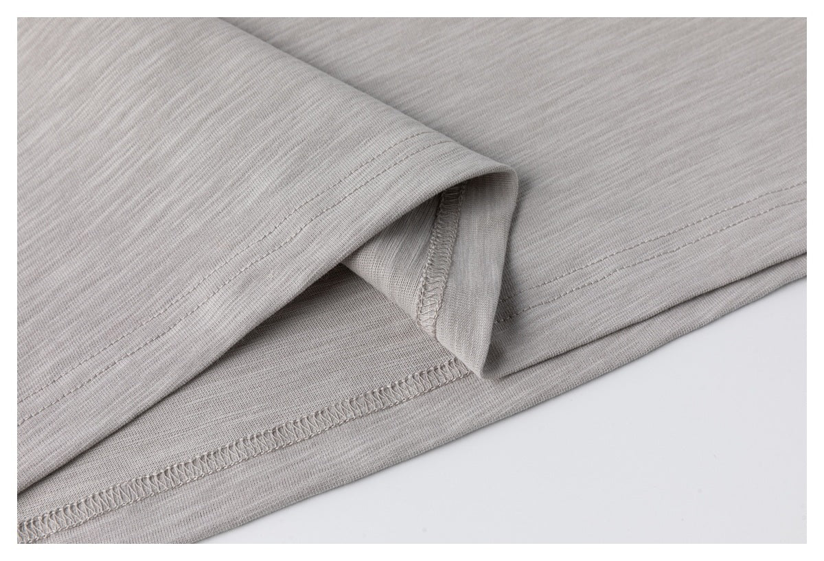Close-up of the light gray shirt's inside stitching and folded bottom hem.