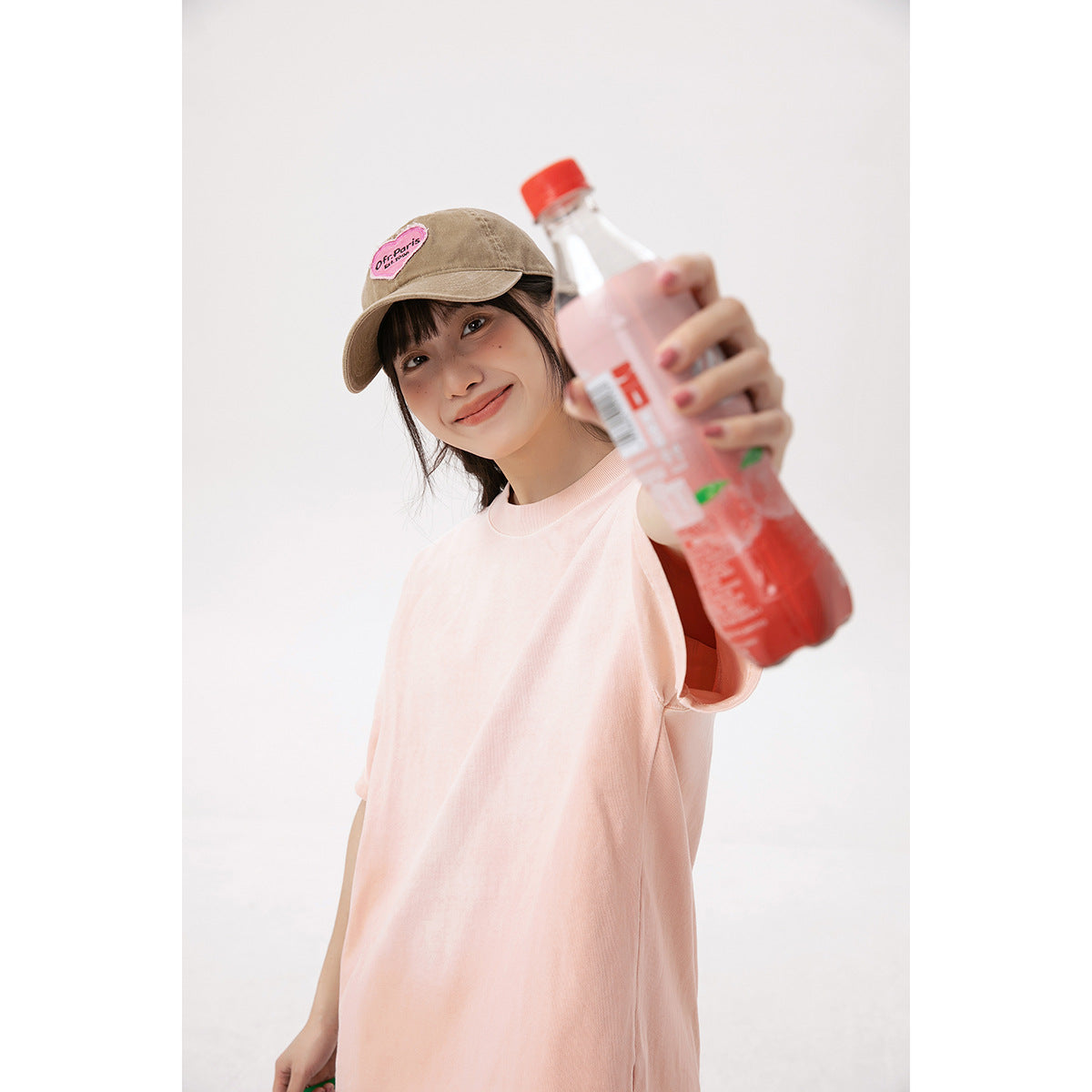 Model wearing an oversized pale pink short-sleeve T-shirt, shown from the front.