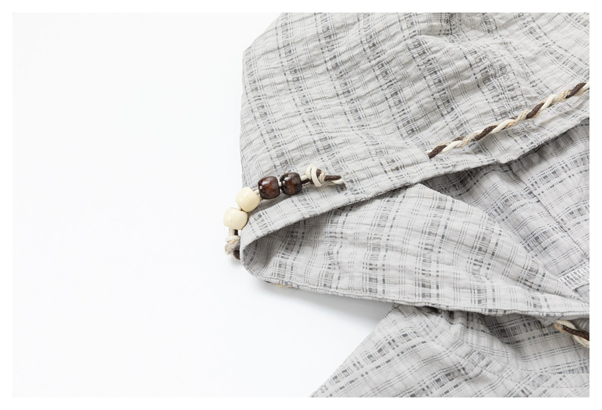 Close-up of the checked hood edge with twisted trim and cream and dark brown beads.
